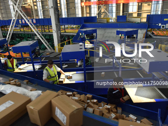 Employees of China Post Express Logistics sort express parcels at an intelligent automatic line in Fuyang, China, on November 7, 2024. (