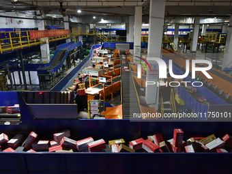 Employees of China Post Express Logistics sort express parcels at an intelligent automatic line in Fuyang, China, on November 7, 2024. (