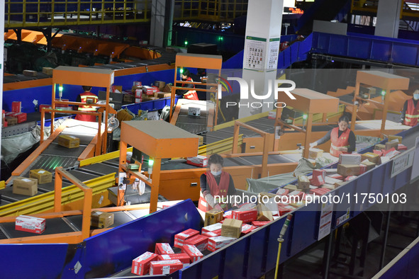 Employees of China Post Express Logistics sort express parcels at an intelligent automatic line in Fuyang, China, on November 7, 2024. 