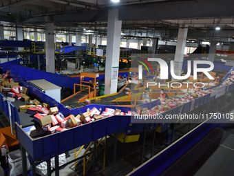 Employees of China Post Express Logistics sort express parcels at an intelligent automatic line in Fuyang, China, on November 7, 2024. (