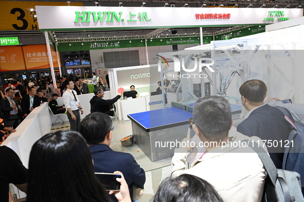 Visitors experience Omron's 9th generation table tennis coaching robot at the Technical equipment exhibition area of the 7th China Internati...