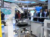 Visitors experience Omron's 9th generation table tennis coaching robot at the Technical equipment exhibition area of the 7th China Internati...