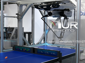 Visitors experience Omron's 9th generation table tennis coaching robot at the Technical equipment exhibition area of the 7th China Internati...