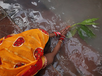 A Hindu devotee lies on the banks of the river Ganges as she offers prayers to the Sun god during the religious festival of Chhat Puja in Ko...