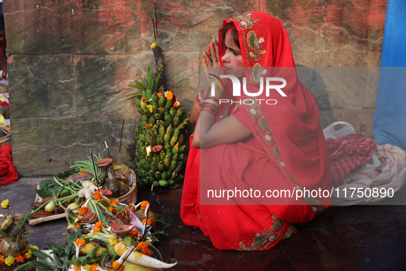 A Hindu woman worships the Sun god Surya on the banks of the river Ganges during the Hindu religious festival of Chhat Puja in Kolkata, Indi...