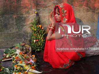 A Hindu woman worships the Sun god Surya on the banks of the river Ganges during the Hindu religious festival of Chhat Puja in Kolkata, Indi...