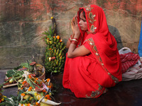 A Hindu woman worships the Sun god Surya on the banks of the river Ganges during the Hindu religious festival of Chhat Puja in Kolkata, Indi...