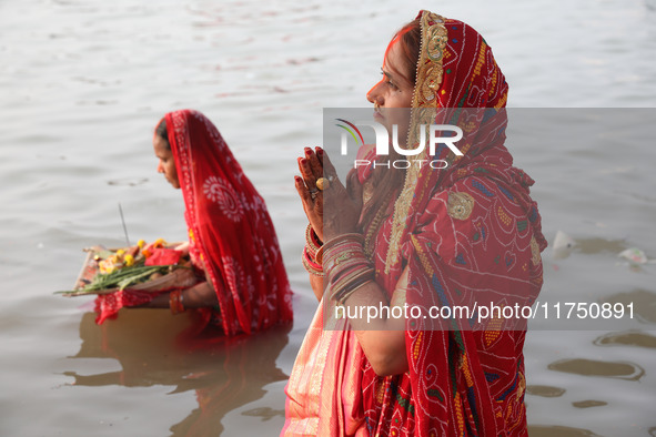 Hindu devotees stand in the waters of the river Ganges to offer prayers to the Sun god during the Hindu religious festival of Chhat Puja in...