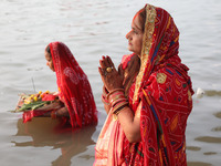 Hindu devotees stand in the waters of the river Ganges to offer prayers to the Sun god during the Hindu religious festival of Chhat Puja in...