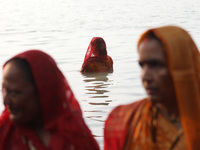 Hindu devotees stand in the waters of the river Ganges to offer prayers to the Sun god during the Hindu religious festival of Chhat Puja in...