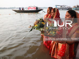 Hindu devotees hold offerings as they stand in the waters of the river Ganges to offer prayers to the Sun god during the Hindu religious fes...