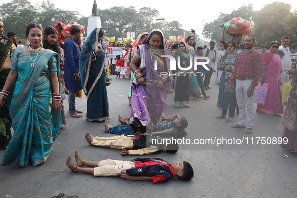 A Hindu woman steps over children in a ritual seeking blessings for the child from the Sun god during the religious festival of Chhat Puja i...