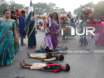 A Hindu woman steps over children in a ritual seeking blessings for the child from the Sun god during the religious festival of Chhat Puja i...