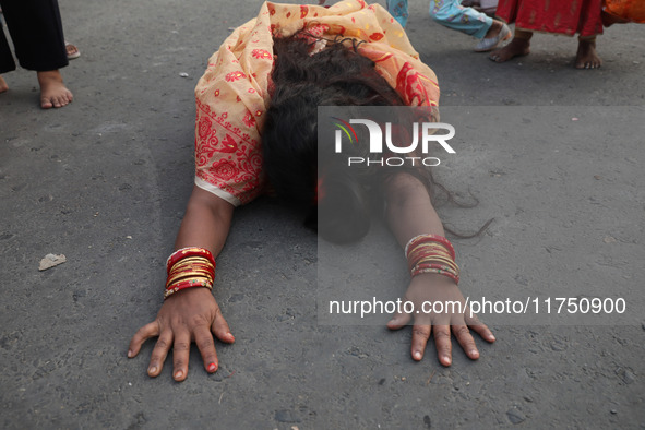 A Hindu devotee lies on the road as she worships the Sun god during the Hindu religious festival of Chhat Puja in Kolkata, India, on Novembe...