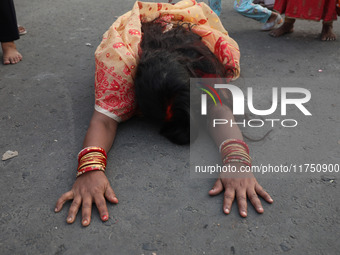 A Hindu devotee lies on the road as she worships the Sun god during the Hindu religious festival of Chhat Puja in Kolkata, India, on Novembe...