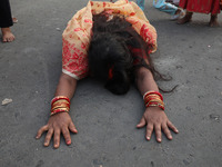 A Hindu devotee lies on the road as she worships the Sun god during the Hindu religious festival of Chhat Puja in Kolkata, India, on Novembe...