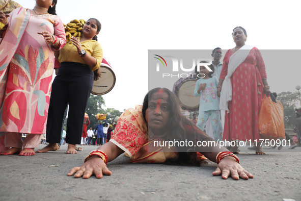 A Hindu devotee lies on the road as she worships the Sun god during the Hindu religious festival of Chhat Puja in Kolkata, India, on Novembe...