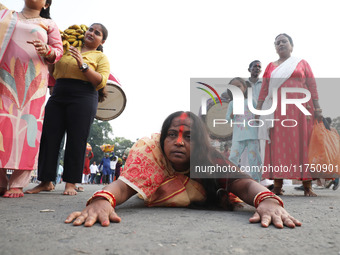 A Hindu devotee lies on the road as she worships the Sun god during the Hindu religious festival of Chhat Puja in Kolkata, India, on Novembe...