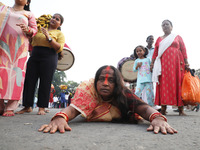 A Hindu devotee lies on the road as she worships the Sun god during the Hindu religious festival of Chhat Puja in Kolkata, India, on Novembe...