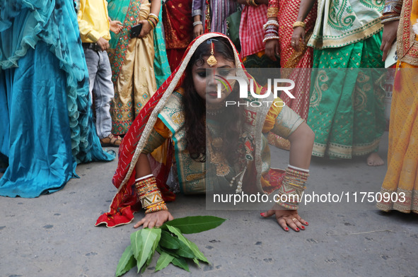 A Hindu devotee lies on the road as she worships the Sun god during the Hindu religious festival of Chhat Puja in Kolkata, India, on Novembe...