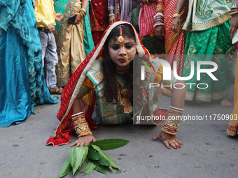 A Hindu devotee lies on the road as she worships the Sun god during the Hindu religious festival of Chhat Puja in Kolkata, India, on Novembe...