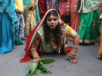 A Hindu devotee lies on the road as she worships the Sun god during the Hindu religious festival of Chhat Puja in Kolkata, India, on Novembe...