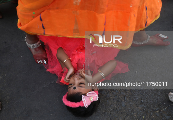 A Hindu woman steps over a child in a ritual seeking blessings for the child from the Sun god during the religious festival of Chhat Puja in...