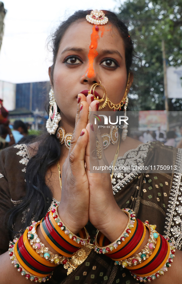 A Hindu woman worships the Sun god Surya on the banks of the river Ganges during the Hindu religious festival of Chhat Puja in Kolkata, Indi...