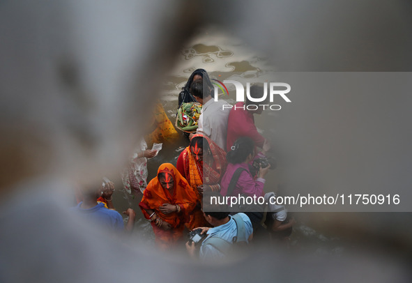 Hindu devotees hold offerings as they worship the Sun god on the banks of the river Ganges during the religious festival of Chhat Puja in Ko...