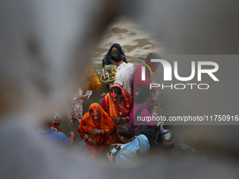 Hindu devotees hold offerings as they worship the Sun god on the banks of the river Ganges during the religious festival of Chhat Puja in Ko...