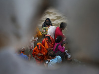 Hindu devotees hold offerings as they worship the Sun god on the banks of the river Ganges during the religious festival of Chhat Puja in Ko...