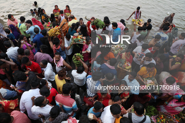 Hindu devotees hold offerings as they worship the Sun god on the banks of the river Ganges during the religious festival of Chhat Puja in Ko...