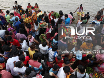 Hindu devotees hold offerings as they worship the Sun god on the banks of the river Ganges during the religious festival of Chhat Puja in Ko...