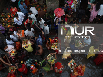 Hindu devotees hold offerings as they worship the Sun god on the banks of the river Ganges during the religious festival of Chhat Puja in Ko...