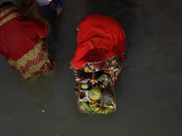 Hindu devotees hold offerings as they worship the Sun god on the banks of the river Ganges during the religious festival of Chhat Puja in Ko...