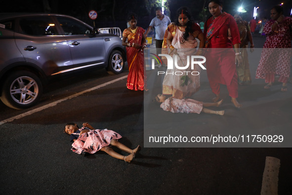 A Hindu woman steps over a child in a ritual seeking blessings for the child from the Sun god during the religious festival of Chhat Puja in...