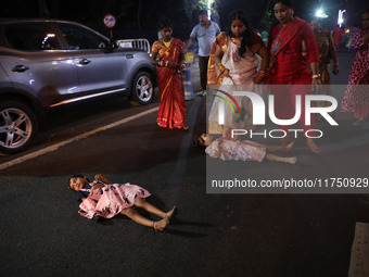 A Hindu woman steps over a child in a ritual seeking blessings for the child from the Sun god during the religious festival of Chhat Puja in...