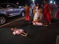 A Hindu woman steps over a child in a ritual seeking blessings for the child from the Sun god during the religious festival of Chhat Puja in...