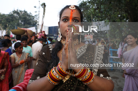 A Hindu woman worships the Sun god Surya on the banks of the river Ganges during the Hindu religious festival of Chhat Puja in Kolkata, Indi...