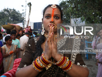 A Hindu woman worships the Sun god Surya on the banks of the river Ganges during the Hindu religious festival of Chhat Puja in Kolkata, Indi...