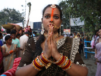 A Hindu woman worships the Sun god Surya on the banks of the river Ganges during the Hindu religious festival of Chhat Puja in Kolkata, Indi...