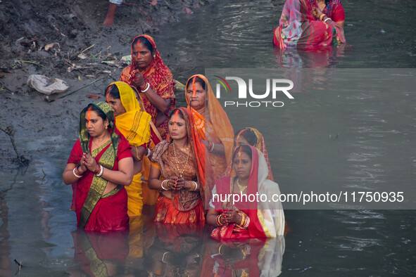 Devotees offer prayers to the sun god at a riverside 70 kilometers outside of Kolkata, India, on November 7, 2024, during the Chhath Puja fe...