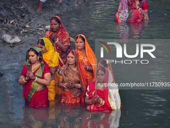 Devotees offer prayers to the sun god at a riverside 70 kilometers outside of Kolkata, India, on November 7, 2024, during the Chhath Puja fe...