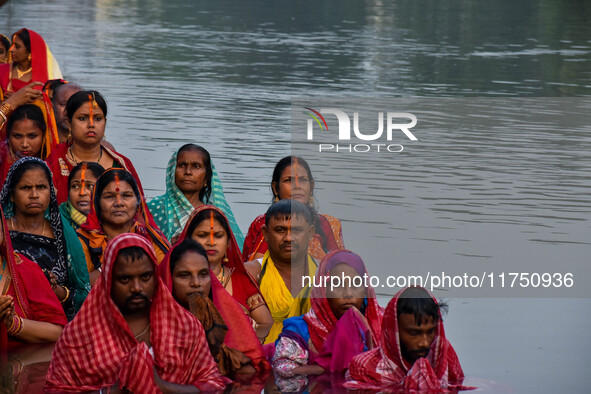 Devotees offer prayers to the sun god at a riverside 70 kilometers outside of Kolkata, India, on November 7, 2024, during the Chhath Puja fe...