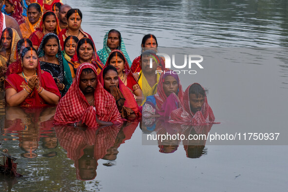 Devotees offer prayers to the sun god at a riverside 70 kilometers outside of Kolkata, India, on November 7, 2024, during the Chhath Puja fe...