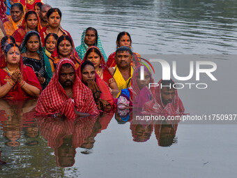 Devotees offer prayers to the sun god at a riverside 70 kilometers outside of Kolkata, India, on November 7, 2024, during the Chhath Puja fe...