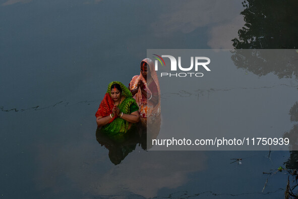 Devotees offer prayers to the sun god at a riverside 70 kilometers outside of Kolkata, India, on November 7, 2024, during the Chhath Puja fe...