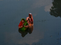 Devotees offer prayers to the sun god at a riverside 70 kilometers outside of Kolkata, India, on November 7, 2024, during the Chhath Puja fe...