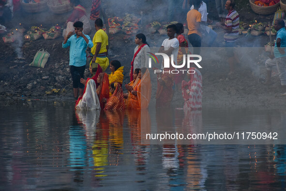 Devotees offer prayers to the sun god at a riverside 70 kilometers outside of Kolkata, India, on November 7, 2024, during the Chhath Puja fe...