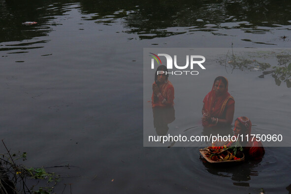 Devotees offer prayers to the sun god at a riverside 70 kilometers outside of Kolkata, India, on November 7, 2024, during the Chhath Puja fe...